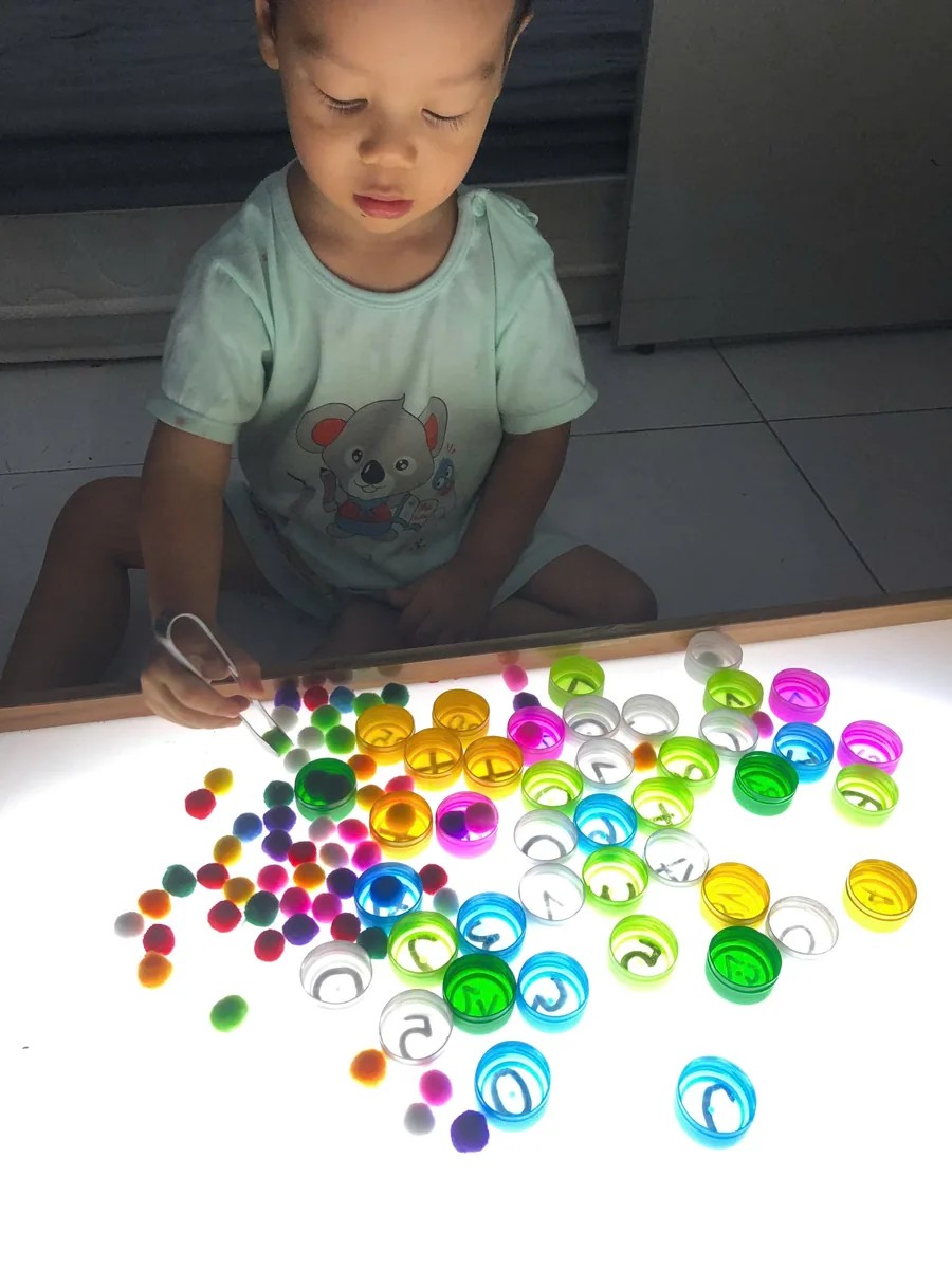 Bé Míp chơi vận động tinh — dùng kẹp gắp, phân loại trên bàn ánh sáng